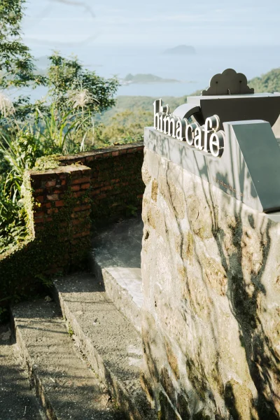 Stone steps and Hima Café sign overlooking the sea from Jiufen in afternoon light